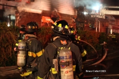 NEW YORK - Multi- Alarm residential fire guts home. Firefighters work to extinguish rapid moving fire. While Firefighters work on the fire Emergency Medical Service personnel wait to attend the injured.