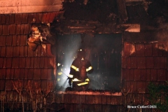 NEW YORK - Multi- Alarm residential fire guts home. Firefighters work to extinguish rapid moving fire. While Firefighters work on the fire Emergency Medical Service personnel wait to attend the injured.
