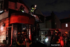 NEW YORK - Multi- Alarm residential fire guts home. Firefighters work to extinguish rapid moving fire. While Firefighters work on the fire Emergency Medical Service personnel wait to attend the injured.