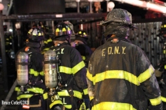 NEW YORK - Multi- Alarm residential fire guts home. Firefighters work to extinguish rapid moving fire. While Firefighters work on the fire Emergency Medical Service personnel wait to attend the injured.