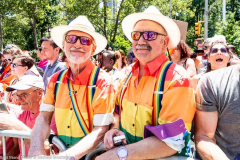 Two spectators in rainbow colored shitrts at the New York City Pride March.