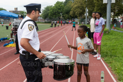 A member of the NYPD marching band interacts with a young person at the inaugural flag football tournament in memory of Det. Keith Williams. (Photo by Gabriele Holtermann)