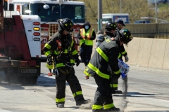 firefighters work to secure a tractor trailer that flipped over and sent 100's of gallons spilling onto the Brooklyn- Queens Expressway at Flushing Avenue.
