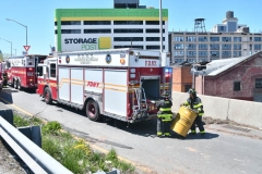 firefighters work to secure a tractor trailer that flipped over and sent 100's of gallons spilling onto the Brooklyn- Queens Expressway at Flushing Avenue.