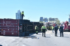 Cops, firefighters and big rig towers work to secure a tractor trailer that flipped over and sent 100's of gallons spilling onto the Brooklyn- Queens Expressway at Flushing Avenue.