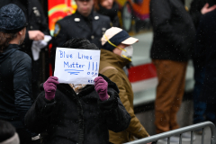 A supporter of the NYPD Holds up a sign for slain officer Jason Rivera.