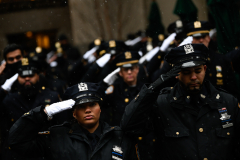 Officers salute the casket of slain officer Jason Rivera.