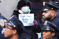A person holds a sign outside St. Patrick's Cathedral during the funeral of slain NYPD officer Jason Rivera in NYC. The 22-year-old NYPD officer was shot and killed on January 21 in Harlem while responding to a domestic disturbance call. Rivera's partner, Officer Wilbert Mora, also died from injuries suffered in the shooting