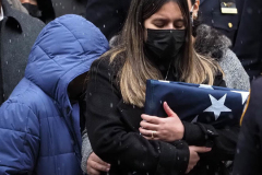 Dominique Rivera, the wife of fallen NYPD Officer Jason Rivera, holds a flag from his casket during his funeral at St. Patrick's Cathedral on January 28, 2022 in New York City. The 22-year-old NYPD officer was shot and killed on January 21 in Harlem while responding to a domestic disturbance call. Rivera's partner, Officer Wilbert Mora, also died from injuries suffered in the shooting