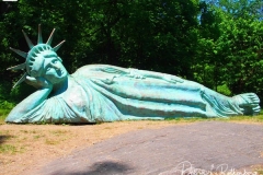 Artist Zaq Landsberg's sculpture entitled "Reclining Liberty" inside Morningside Park in New York City .The sculpture was created by Landsberg and features the Statue of Liberty posed on her side with her head propped up by her hand. The 25 foot long sculpture  is covered in oxidized copper paint and features a steel crown and was created using wood, foam and plaster resin.