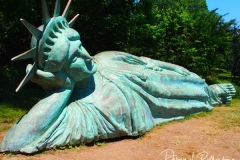 Artist Zaq Landsberg's sculpture entitled "Reclining Liberty" inside Morningside Park in New York City .The sculpture was created by Landsberg and features the Statue of Liberty posed on her side with her head propped up by her hand. The 25 foot long sculpture  is covered in oxidized copper paint and features a steel crown and was created using wood, foam and plaster resin.
