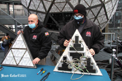 December 27, 2021  New York , Workers Install 192 New Waterford Crystals
On Times Squares New Year’s Eve Ball.The Waterford Crystal New Year’s Eve Ball is a geodesic sphere, 12 feet in diameter, and weighs 11,875 pounds. The Ball is covered with a total of 2,688 Waterford Crystal triangles that vary in size, and range in length from 4 3/4 inches to 5 3/4 inches per side. For Times Square 2022,
