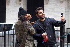 December 13,2020  Wall Street in front of the New York Stock Exchange residents and tourists visit the Fearless Girl statue and take photographs by the Stock exchange Christmas tree.