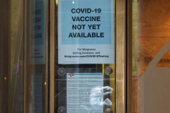 December 13,2020  Wall Street in front of the New York Stock Exchange residents and tourists visit the Fearless Girl statue and take photographs by the Stock exchange Christmas tree.