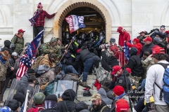Washington, DC - January 6, 2021: Rioters clash with police trying to enter Capitol building through the front doors