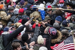 Washington, DC - January 6, 2021: Rioters clash with police trying to enter Capitol building through the front doors