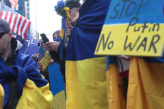 March 5, 2022: A demonstration supporting the Ukraine against the recent attack by Russia took place in Times Square. Protesters wearing Ukrainian flags. Another protester behind them flying the NATO flag and US Flag.
