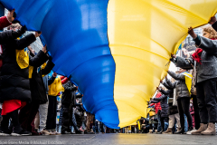 February 24, 2022 - New York, NY, United States: Demonstrators holding a very large Ukrainian flag at a "Stop Putin" rally organized as a response to the war in Ukraine.