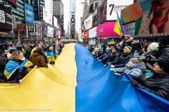 February 24, 2022 - New York, NY, United States: Demonstrators holding a very large Ukrainian flag at a "Stop Putin" rally organized as a response to the war in Ukraine.