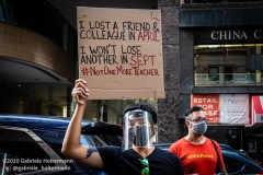 A teachers holds a sign remembering his colleague who died of COVID-19, while a coalition of activists, educators, parents, and students protest to stop the in-person reopening of  New York City public schools amidst the COOVID-19 pandemic in New York City on August 3, 2020. (Photo by Gabriele Holtermann/Sipa USA)