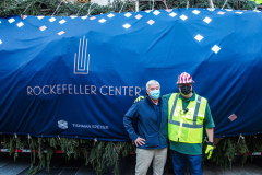 Devon Price, donator of this year’s Rockefeller Christmas Tree poses in front of tree.
 The Rockefeller Christmas Tree arrived at Rockefeller Plaza, Manhattan, NYC on the morning of November 13, 2021. 
Spectators flocked to watch the spectacle as well as those involved in the assembly and press after last year’s event was restricted due to COVID.
People came together and enjoyed the impressive 12 ton and 85 year old Norway Spruce tree, coming from a donation via a family  Elkton, Maryland. This is the first Maryland tree that has ever been chosen in this tradition as the Rockefeller Center Tree.
 (C) Bianca Otero. NYC. November 13, 2021.