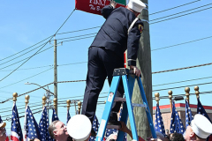 Street Naming
Lilac Court and Forest Avenue
Mariners Harbor
Staten Island, NY
April 22, 2022
Photographs by Mary DiBiase Blaich

The interaction of Lilac Court and Forest Avenue was renamed in a ceremony on Friday, April 22, 2022 for Nicholas M Troianiello, a World War II veteran of the Battle of Iwo Jima who served with the Marines.  Upon returning from service, he joined the FDNY and rose to the rank of Lieutenant, serving in Ladder 15 in Manhattan. He was a Purple Heart recipient.
At the ceremony, many groups gathered to honor Mr Troianiello including The Marine Corps League, the FDNY Retirees Association and current members of the FDNY.  Also in attendance were Congresswoman Nicole Malliotakis; Boro President Vito Fossella;  City Councilwoman Kamillah Hanks and two color guards: Marines 6th Communication Battalion and the FDNY Ceremonial Unit.  The Marine Corps League gave a 21 gun salute, and Frank Montella played Taps.  Carmella Montella needed a box to reach the microphone as she delivered the Invocation.