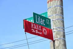 Street Naming
Lilac Court and Forest Avenue
Mariners Harbor
Staten Island, NY
April 22, 2022
Photographs by Mary DiBiase Blaich

The interaction of Lilac Court and Forest Avenue was renamed in a ceremony on Friday, April 22, 2022 for Nicholas M Troianiello, a World War II veteran of the Battle of Iwo Jima who served with the Marines.  Upon returning from service, he joined the FDNY and rose to the rank of Lieutenant, serving in Ladder 15 in Manhattan. He was a Purple Heart recipient.
At the ceremony, many groups gathered to honor Mr Troianiello including The Marine Corps League, the FDNY Retirees Association and current members of the FDNY.  Also in attendance were Congresswoman Nicole Malliotakis; Boro President Vito Fossella;  City Councilwoman Kamillah Hanks and two color guards: Marines 6th Communication Battalion and the FDNY Ceremonial Unit.  The Marine Corps League gave a 21 gun salute, and Frank Montella played Taps.  Carmella Montella needed a box to reach the microphone as she delivered the Invocation.