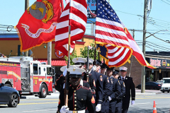 Street Naming
Lilac Court and Forest Avenue
Mariners Harbor
Staten Island, NY
April 22, 2022
Photographs by Mary DiBiase Blaich

The interaction of Lilac Court and Forest Avenue was renamed in a ceremony on Friday, April 22, 2022 for Nicholas M Troianiello, a World War II veteran of the Battle of Iwo Jima who served with the Marines.  Upon returning from service, he joined the FDNY and rose to the rank of Lieutenant, serving in Ladder 15 in Manhattan. He was a Purple Heart recipient.
At the ceremony, many groups gathered to honor Mr Troianiello including The Marine Corps League, the FDNY Retirees Association and current members of the FDNY.  Also in attendance were Congresswoman Nicole Malliotakis; Boro President Vito Fossella;  City Councilwoman Kamillah Hanks and two color guards: Marines 6th Communication Battalion and the FDNY Ceremonial Unit.  The Marine Corps League gave a 21 gun salute, and Frank Montella played Taps.  Carmella Montella needed a box to reach the microphone as she delivered the Invocation.