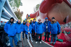 Macy’s Parade Balloon Inflation was held along NYC’s Central Park West on 11/24/21.  Balloons of various colors and sizes were on display to the public This is as an annual event, the night before the Macy’s parade.  Here the helium crew pose for a photo.  Copyright Jon Simon