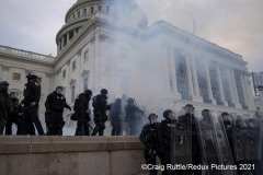 After supporters stormed the building earlier, police are caught in a haze after smoke canisters and chemical irritants were dispatched by police on the steps of the United States Capitol in Washington, D.C., Wednesday, Jan. 6, 2020, as they protest the electoral college certification of President-Elect Joe Biden.