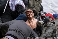 Supporters of President Trump, one carrying a bust of the President, climb the walls of the United States Capitol in Washington, D.C., Wednesday, Jan. 6, 2020, as they and thousands of others protest the electoral college certification of President-Elect Joe Biden.
