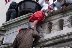 Supporters of President Donald Trump ascend a wall as they hold their ground after storming the United States Capitol in Washington, D.C., Wednesday, Jan. 6, 2020, as they protest the electoral college certification of President-Elect Joe Biden.