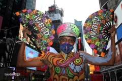 New York City. "The Crossroads of the World" Times Square. Andy Golub Artist/Founder of Human Connection Arts paints 3 models in Times square, as onlookers watch and street performers and costume characters entertainvistors.