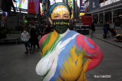 New York City. "The Crossroads of the World" Times Square. Andy Golub Artist/Founder of Human Connection Arts paints 3 models in Times square, as onlookers watch and street performers and costume characters entertainvistors.