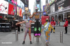 New York City. "The Crossroads of the World" Times Square. Andy Golub Artist/Founder of Human Connection Arts paints 3 models in Times square, as onlookers watch and street performers and costume characters entertainvistors.