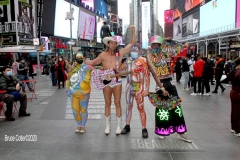 New York City. "The Crossroads of the World" Times Square. Andy Golub Artist/Founder of Human Connection Arts paints 3 models in Times square, as onlookers watch and street performers and costume characters entertainvistors.