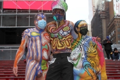 New York City. "The Crossroads of the World" Times Square. Andy Golub Artist/Founder of Human Connection Arts paints 3 models in Times square, as onlookers watch and street performers and costume characters entertainvistors.