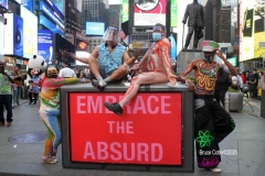 New York City. "The Crossroads of the World" Times Square. Andy Golub Artist/Founder of Human Connection Arts paints 3 models in Times square, as onlookers watch and street performers and costume characters entertainvistors.
