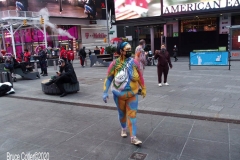 New York City. "The Crossroads of the World" Times Square. Andy Golub Artist/Founder of Human Connection Arts paints 3 models in Times square, as onlookers watch and street performers and costume characters entertainvistors.