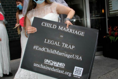 New York,   N.Y.. –Unchained At Last and advocates dressed in bridal gowns and veils, with arms chained and mouths taped, gathered in Manhattan outside Gov. Cuomo’s office to celebrate that New York just became the sixth state to end child marriage.