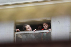 Children look from a window of train carrying refugees from Ukraine arrives to Przemysl station in Poland on March 3, 2022