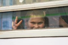 A child makes the “V” for victory sign after leaving Ukraine aboard a train to Krakow from Przemysl station in Poland on March 3, 2022.