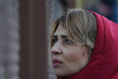 A woman looks for family members through a fence as a train carrying refugees from Ukraine arrives to Przemysl station in Poland on March 3, 2022
