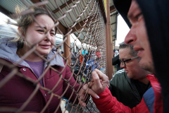 A woman cries when seeing a man through a fence after arriving on a train carrying refugees from Ukraine arrives to Przemysl station in Poland on March 3, 2022