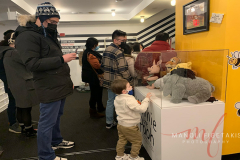 A young child is checking out the Winnie the Pooh display as his dad takes his photo behind him. Located at the Theatre Row (410 W 42nd St., New York on 23 Jan 2022.