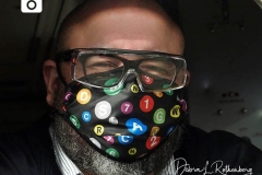 An MTA Conductor in New York City on Christmas Eve wears a mask showing all the various subway lines.