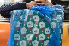 A man rides the #1 subway on Christmas Eve in NYC.